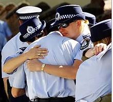 Lean on me ... grieving colleagues comfort each other. Photo: Liam Driver
