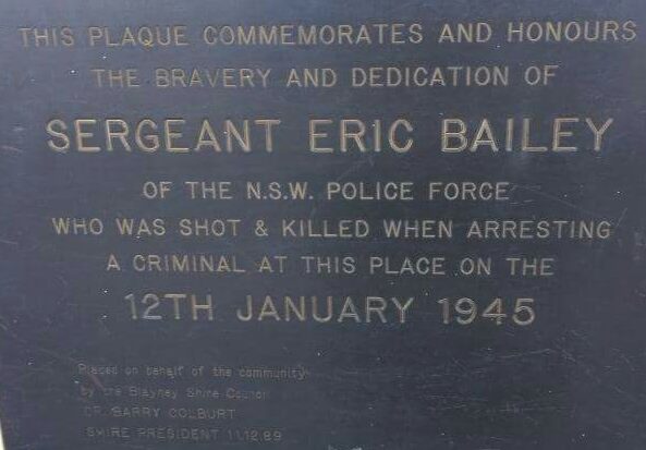 This plaque commemorates and honours the bravery and dedication of Sergeant Eric Bailey of the N.S.W. Police Force who was shot and killed when arresting a criminal at this place on the 12th January 1945. Placed on behlaf of the community by the Blayney Shire Council by Barry Colburt, Shire President, 11 December 1989.