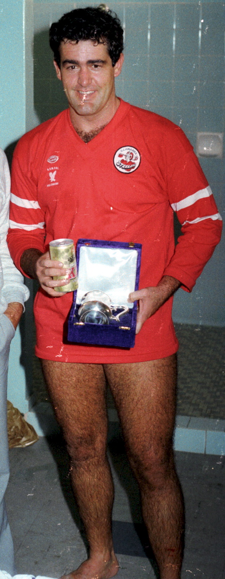Photo by Greg Callander POLICE FOOTBALL. CONSTABLE PAT CARNEY, FROM WOLLONGONG POLICE, RECEIVED THE TOOTH L.A. MAN OF THE MATCH TROPHY IN THE DRESSING SHED OF LYSAGHTS FOOTBALL FIELD, FIGTREE. MALE ON THE LIEFT IS UNKNOWN TO ME. (PAT COMMITTED SUICIDE 10 NOVEMBER 2003. HE WAS A CIVILLIAN AT THAT TIME) 13 APRIL 1983