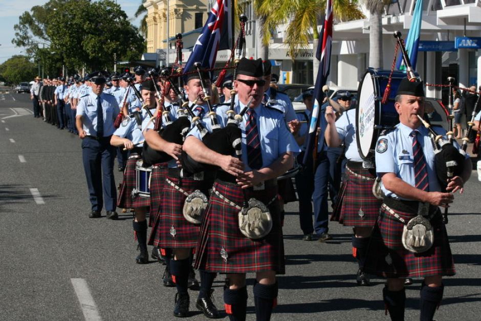 The Queensland Police Pipes and Drums led the march to remember Norm Watt.