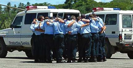 AFP officers farewell their mate Adam Dunning after loading his coffin into a RAAF jet at Honiara Domestic Airport.