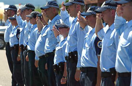 Australian Protective Services officers salute the coffin in a guard of honour at Honiara Domestic Airport before Adam Dunning's coffin was flown back to Australia. Photo: Andy Zakeli