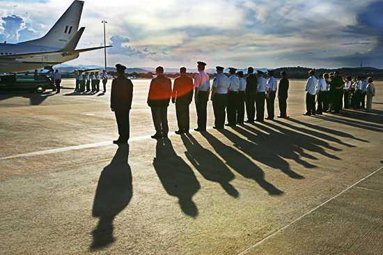 Senior officers and other dignatories, along with family members, watch Adam Dunning's coffin being loaded from the aircraft to a hearse at the RAAF Base at Fairbairn in Canberra. Photo: Andrew Taylor