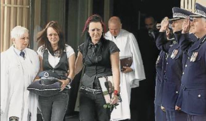 http://www.illawarramercury.com.au/story/605017/thin-blue-line-pays-silent-tribute-to-one-of-their-own/#slide=1 Snr Const Gallagher's daughters Jordann and Jessica with their father's hat and photo. Picture: SYLVIA LIBER