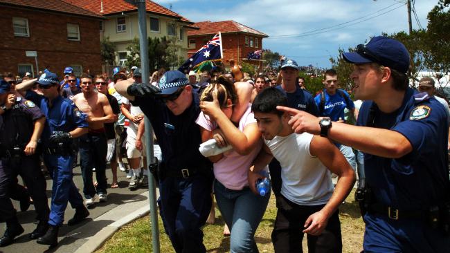Police protect the innocent people from the angry mob. Picture: Craig Greenhill