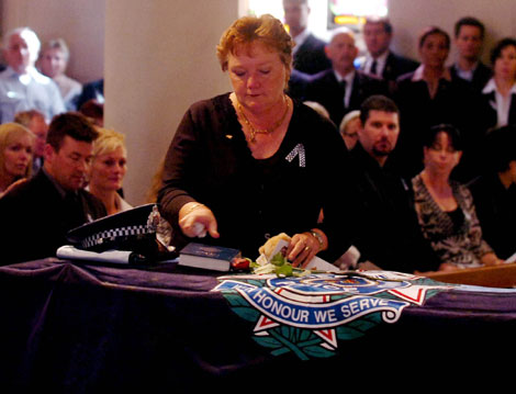 Constable Brett Andrew Irwin's mother Chris Irwin places a bible on her son's casket during the officer's funeral at the St Stephens Cathedral. Picture: AAP/Tony Phillips