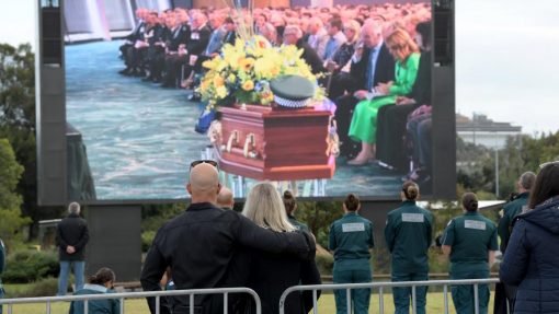 https://www.news.com.au/national/crime/infectious-smile-funeral-held-for-fallen-wa-cop-anthony-woods/news-story/03e2817f3fb43cc1517ec96a9d4d16ef Members of the public gathered outside the stadium to watch the service on a big screen. Picture: NCA NewsWire / Sharon Smith